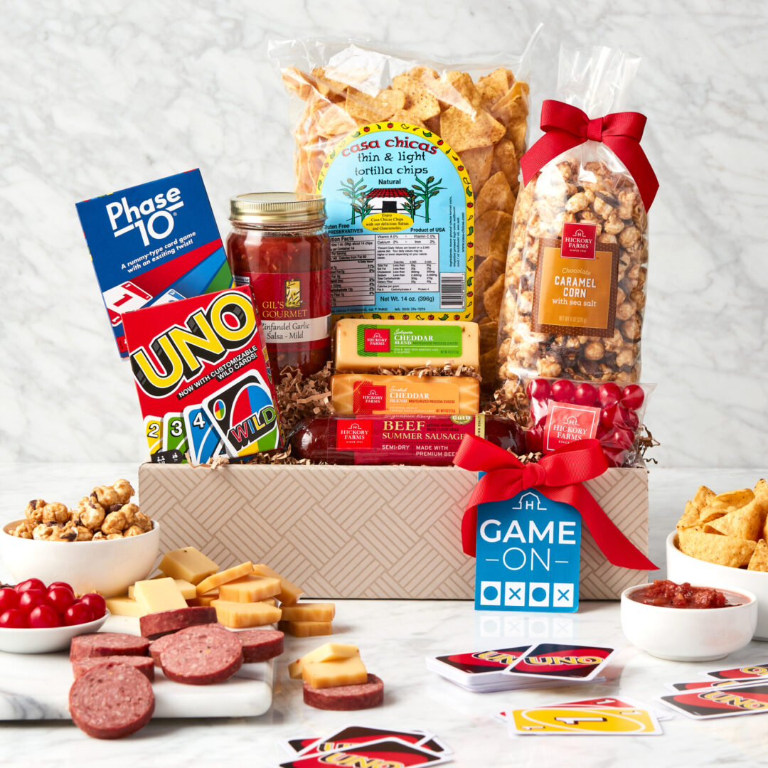 (1) 14 oz Casa Chicas Chips,(1) Gill's Gourmet Salsa,(1) 4 oz Smoked Cheddar,(1) 4 oz Jalapeno Cheddar,(1) 3 oz Cherry Sours,(1) 10 oz Signature Beef Summer Sausage,(1) 8 oz Chocolate Caramel Corn,(1) Phase 10 Game,(1) UNO Game,Lidless Deep Corrugate Box - basketweave,Grosgrain Ribbon - Poppy 7/8"",Game On Hangtag